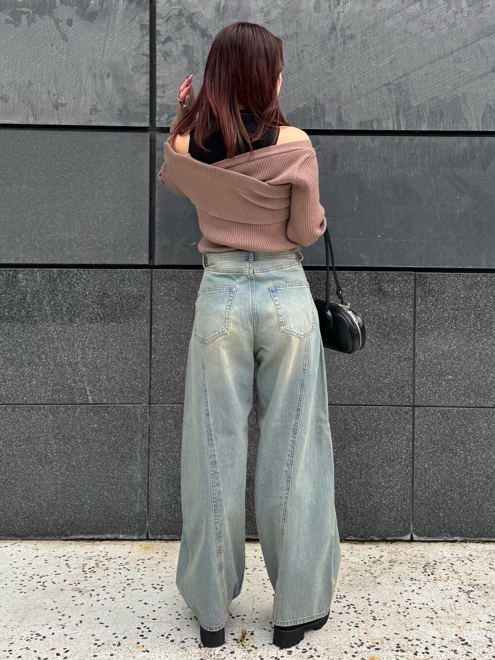 ブラウン系のニット/セーター、ブルー系のデニムパンツ、ブラック系のブーツを着用したレディースの冬コーディネートの3枚目の写真