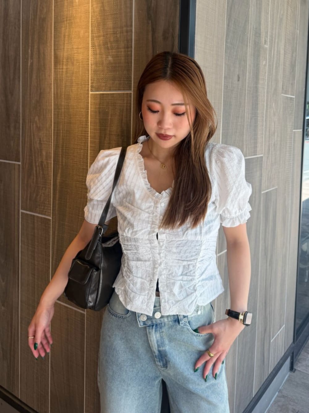 ブラック系のブーツ、ブルー系のデニムパンツ、ホワイト系のシャツ/ブラウスを着用したレディースの夏コーディネートの4枚目の写真