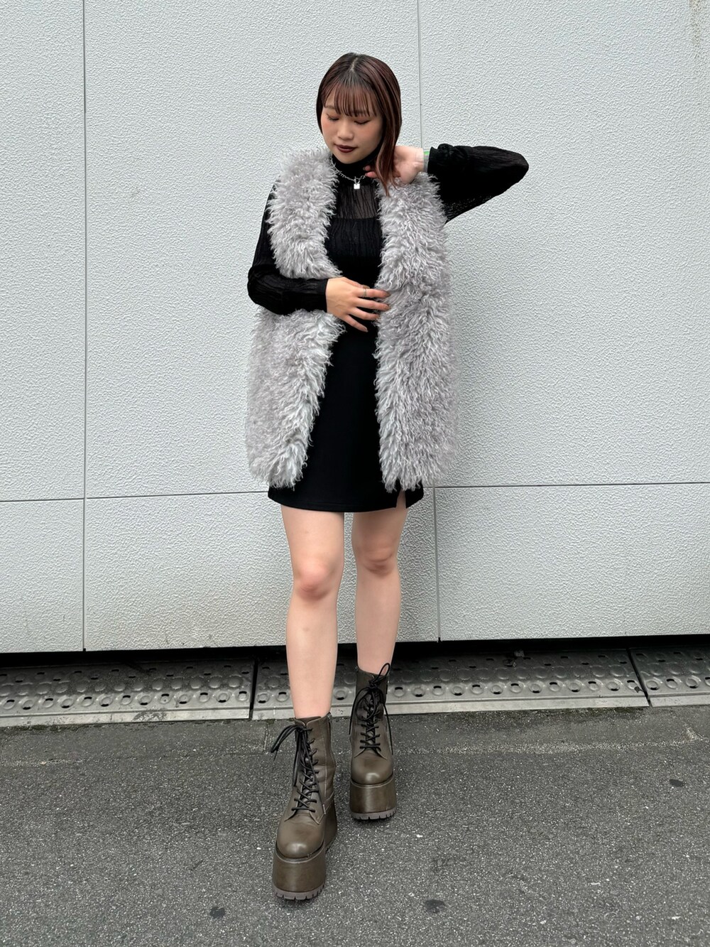 ブラック系のニット/セーター、グレー系のベスト、ブラック系のスカートを着用したレディースの秋コーディネートの4枚目の写真