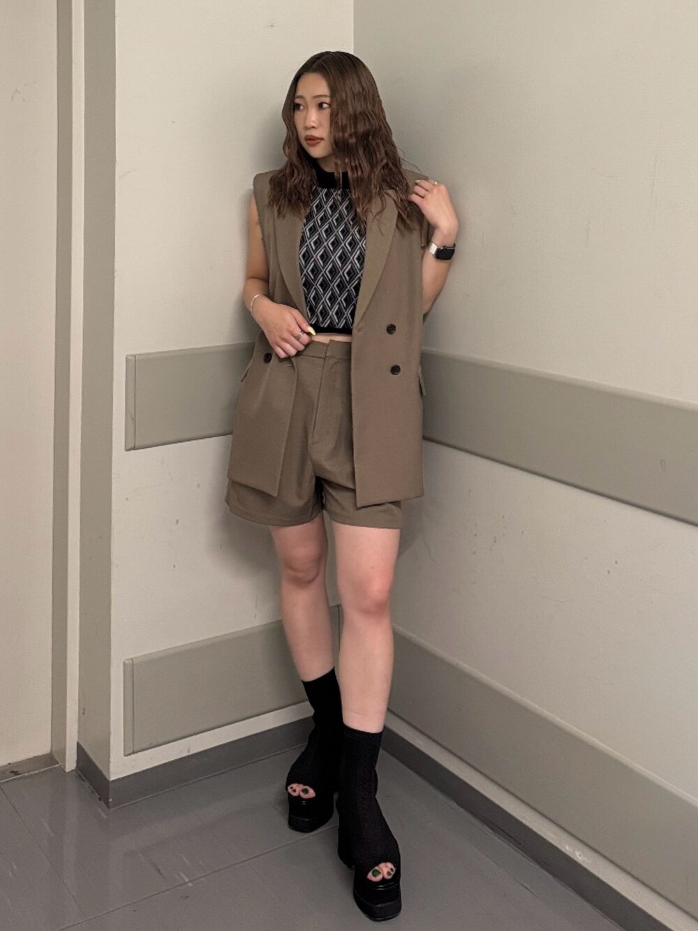 ブラウン系のベスト、ブラック系のタンクトップ、ブラウン系のその他パンツを着用したレディースの夏コーディネートの6枚目の写真