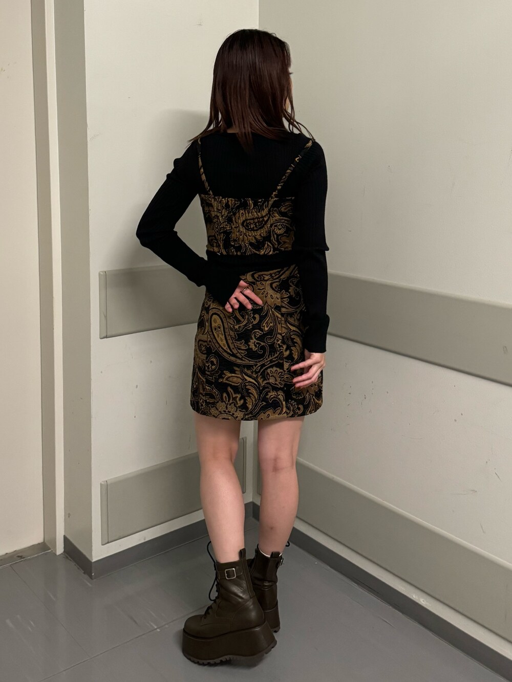 ブラック系のキャミソール、ブラック系のスカート、ブラウン系のブーツを着用したレディースの秋コーディネートの3枚目の写真