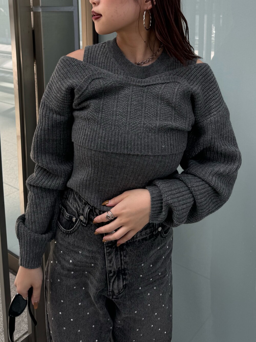 グレー系のニット/セーター、ブラック系のデニムパンツ、ブラウン系のブーツを着用したレディースの秋コーディネートの7枚目の写真