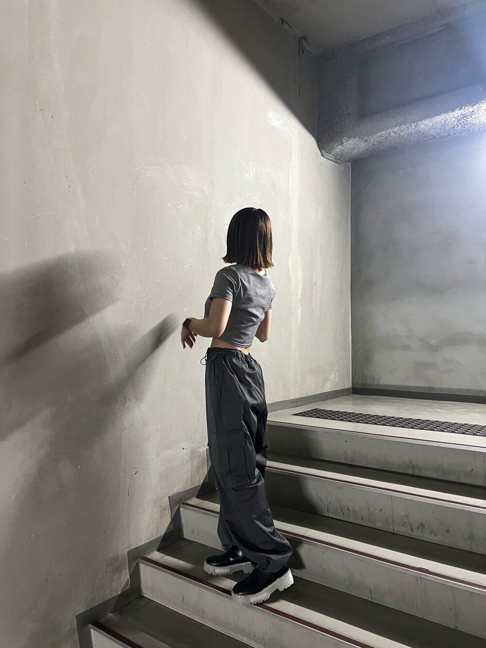 グレー系のカーゴパンツ、その他のTシャツ/カットソー、ブラック系のブーツを着用したレディースの秋コーディネートの4枚目の写真