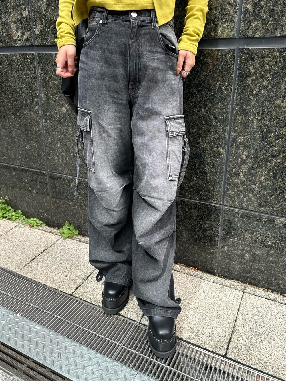 イエロー系のTシャツ/カットソー、ブラック系のデニムパンツ、ブラック系のブーツを着用したレディースの秋コーディネートの8枚目の写真