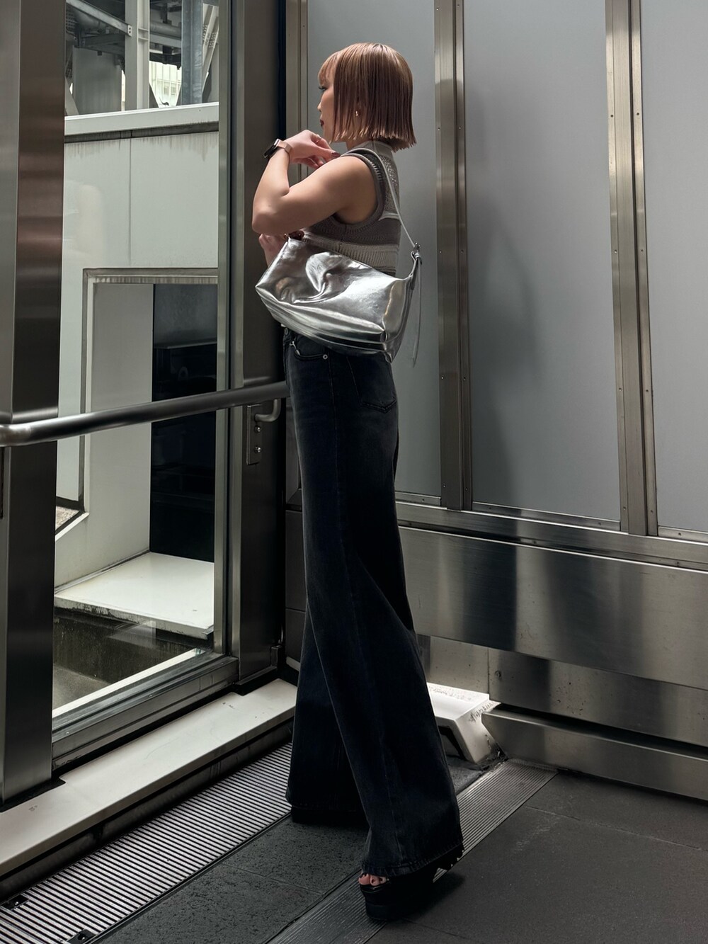 グレー系のニット/セーター、ブラック系のデニムパンツを着用したレディースの春コーディネートの4枚目の写真