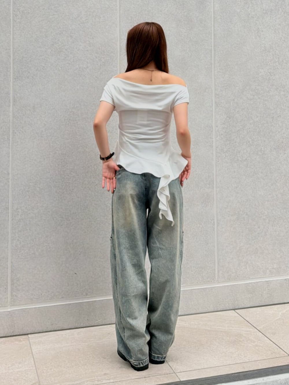 ブラック系のブーツ、ブルー系のデニムパンツ、ホワイト系のTシャツ/カットソーを着用したレディースの夏コーディネートの3枚目の写真