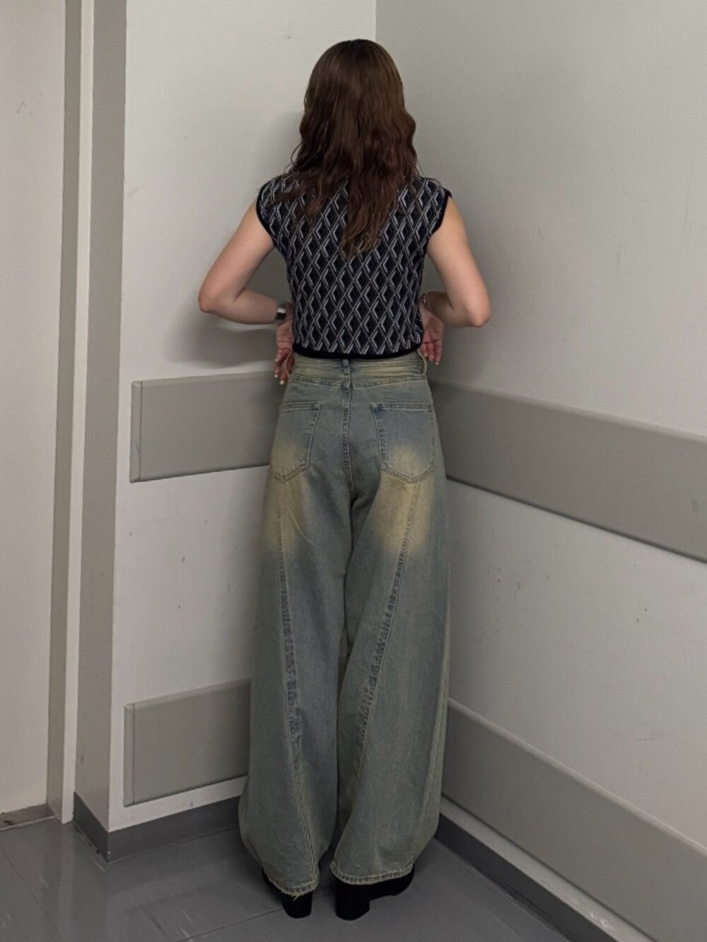 ブルー系のデニムパンツ、ブラック系のタンクトップ、ブラック系のサンダルを着用したレディースの夏コーディネートの3枚目の写真