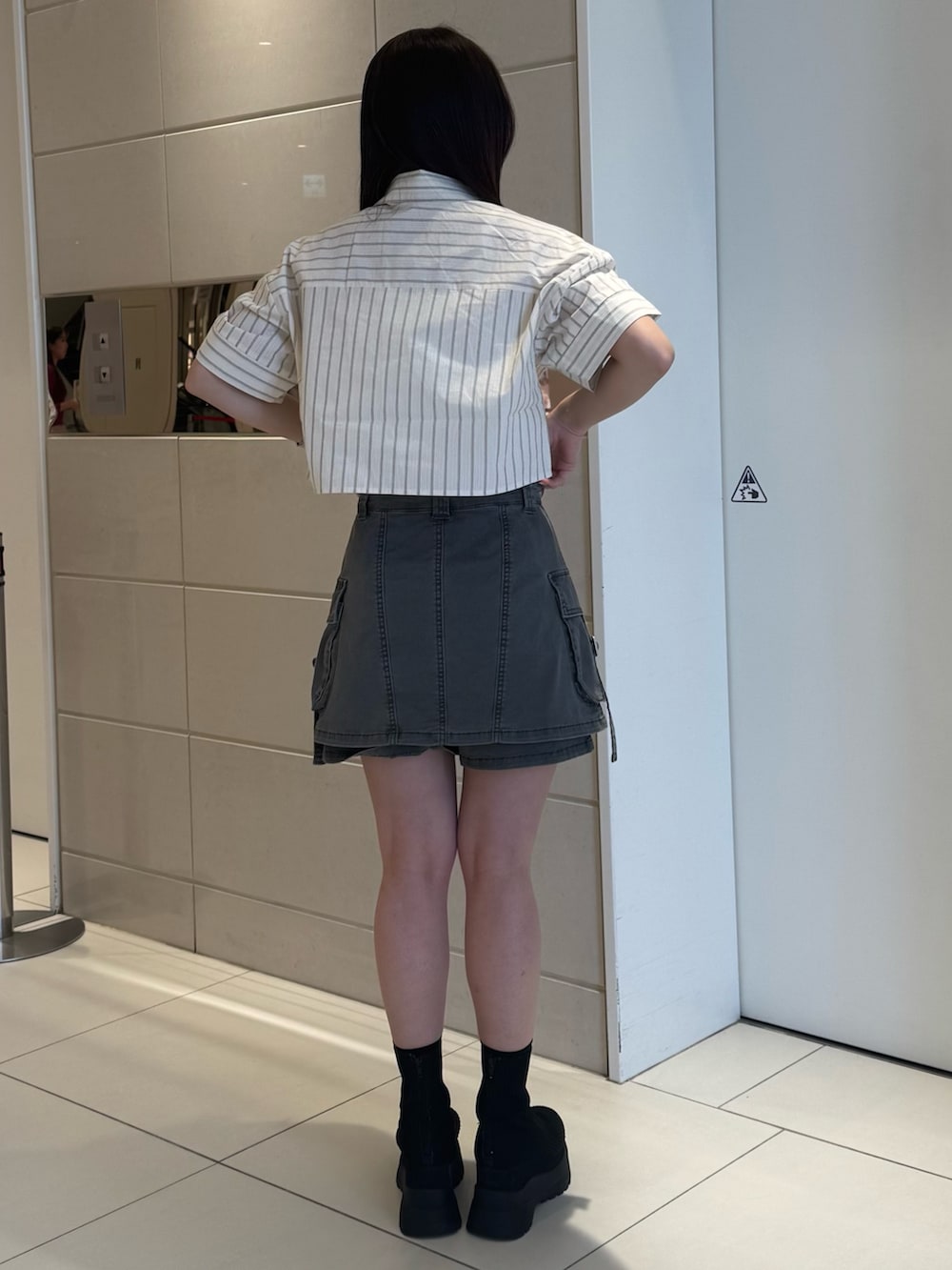 ホワイト系のシャツ/ブラウス、グレー系のスカート、ブラック系のブーツを着用したレディースの春コーディネートの3枚目の写真