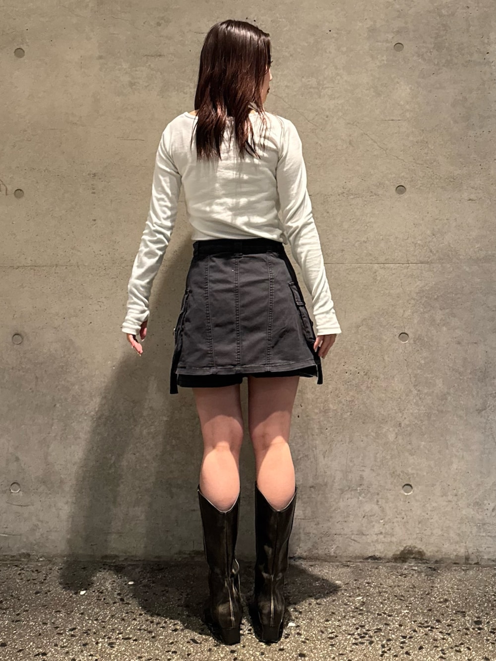 ホワイト系のTシャツ/カットソー、ブラック系のスカート、ブラウン系のブーツを着用したレディースの春コーディネートの3枚目の写真