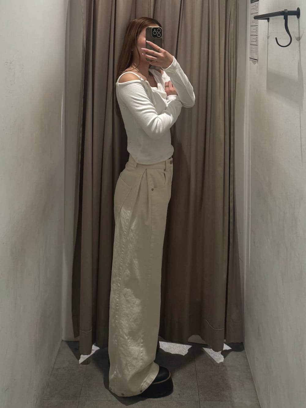 ホワイト系のデニムパンツ、ホワイト系のニット/セーター、ブラック系のブーツを着用したレディースの春コーディネートの2枚目の写真