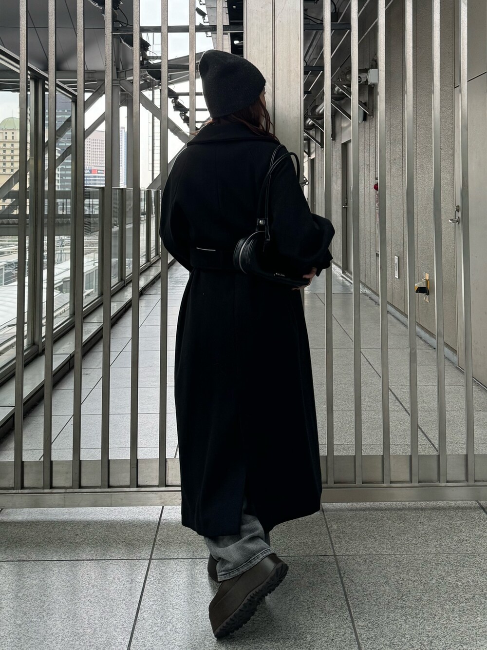 ブラック系のその他アウター、ブラック系のニット/セーター、ブラック系のデニムパンツを着用したレディースの秋コーディネートの3枚目の写真