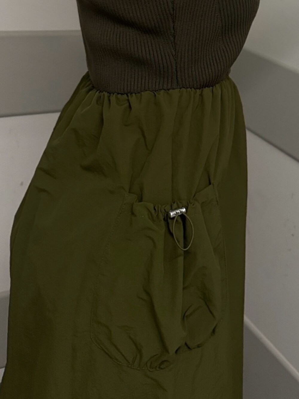 グリーン系のワンピース、ブラック系のサンダルを着用したレディースの夏コーディネートの5枚目の写真