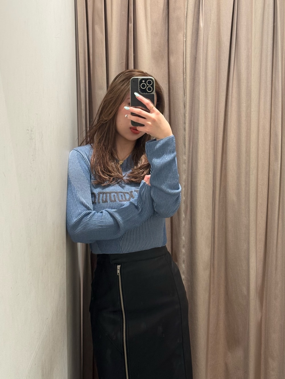 ブルー系のニット/セーター、ブラック系のスカート、ブラック系のブーツを着用したレディースの冬コーディネートの4枚目の写真