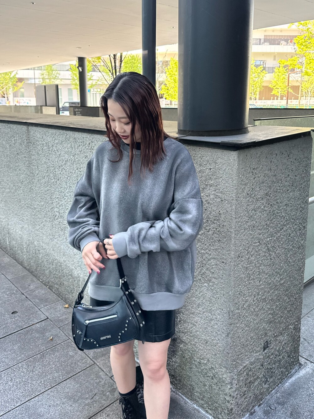 グレー系のスウェット、ブラック系のスカート、ブラック系のハンドバッグを着用したレディースの秋コーディネートの4枚目の写真