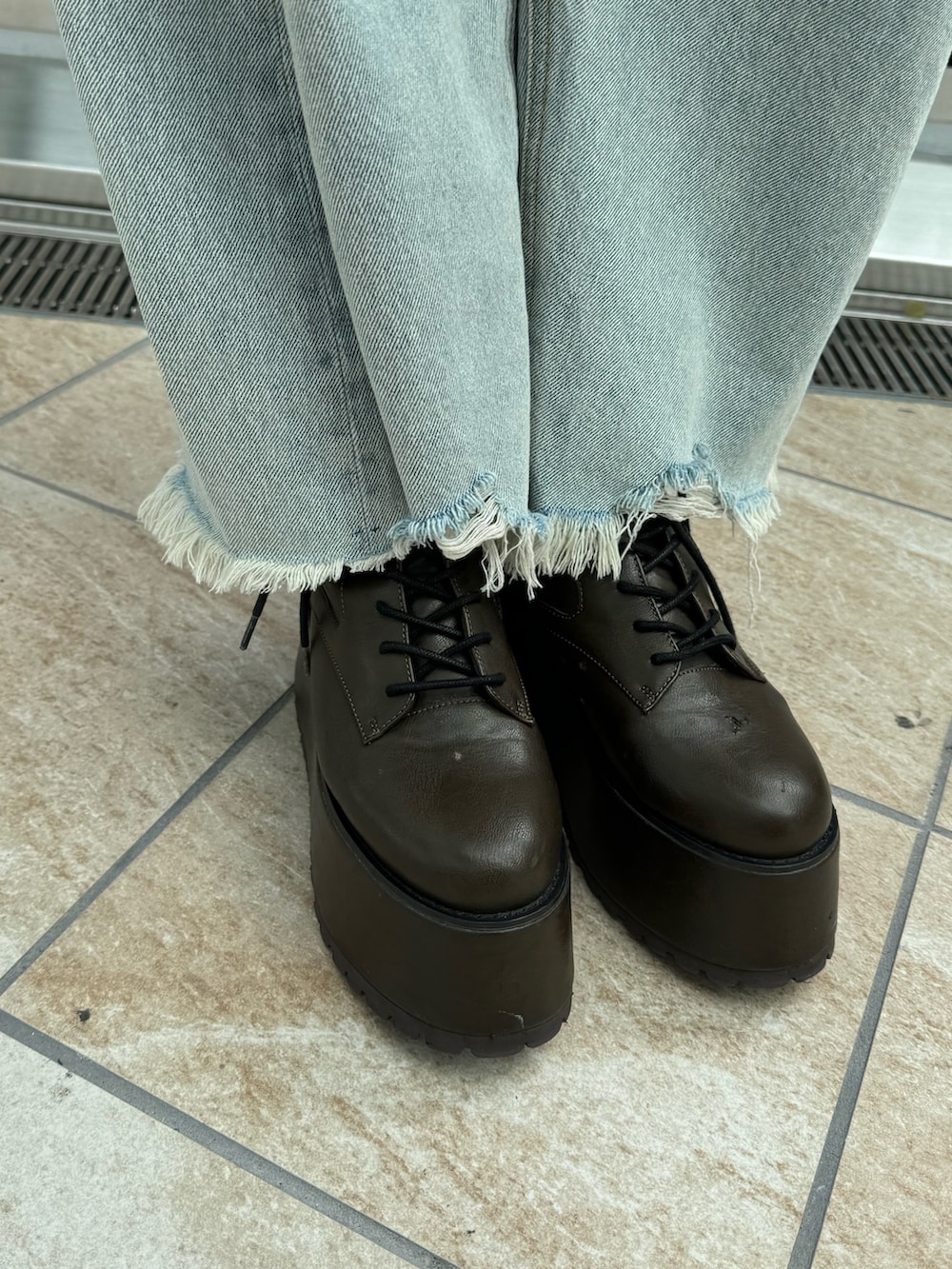 グレー系のニット/セーター、ブルー系のデニムパンツ、ブラウン系のブーツを着用したレディースの秋コーディネートの7枚目の写真