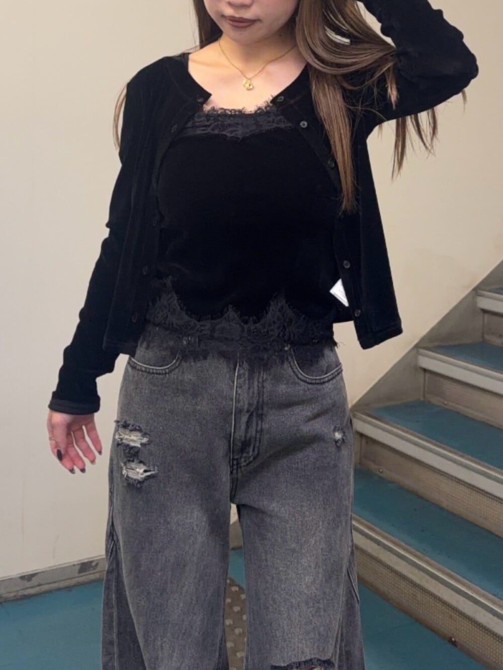 グレー系のデニムパンツ、ブラック系のブーツ、ブラック系のアンサンブルを着用したレディースの秋コーディネートの4枚目の写真