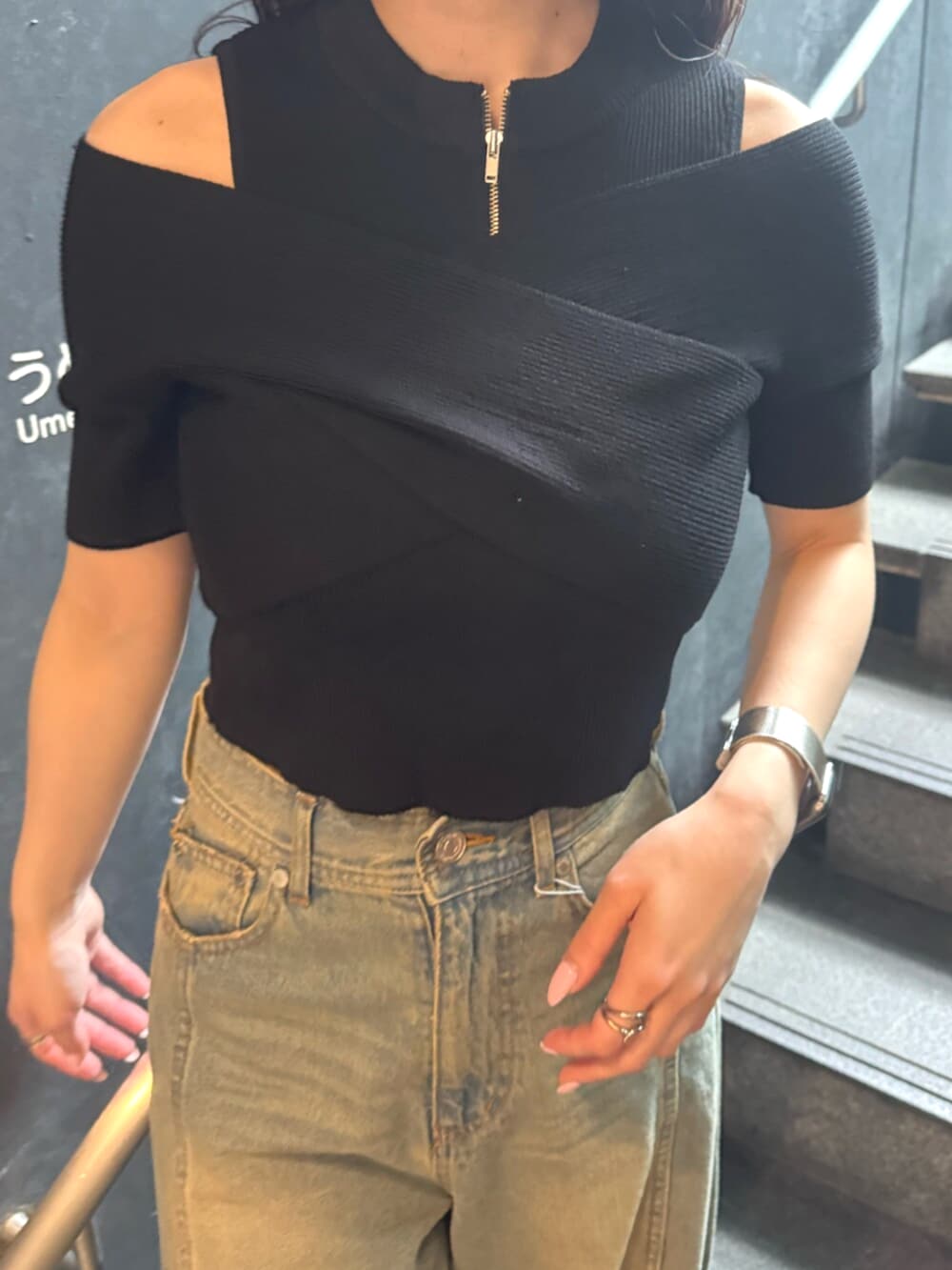 ブルー系のデニムパンツ、ブラック系のブーツ、ブラック系のニット/セーターを着用したレディースの春コーディネートの6枚目の写真