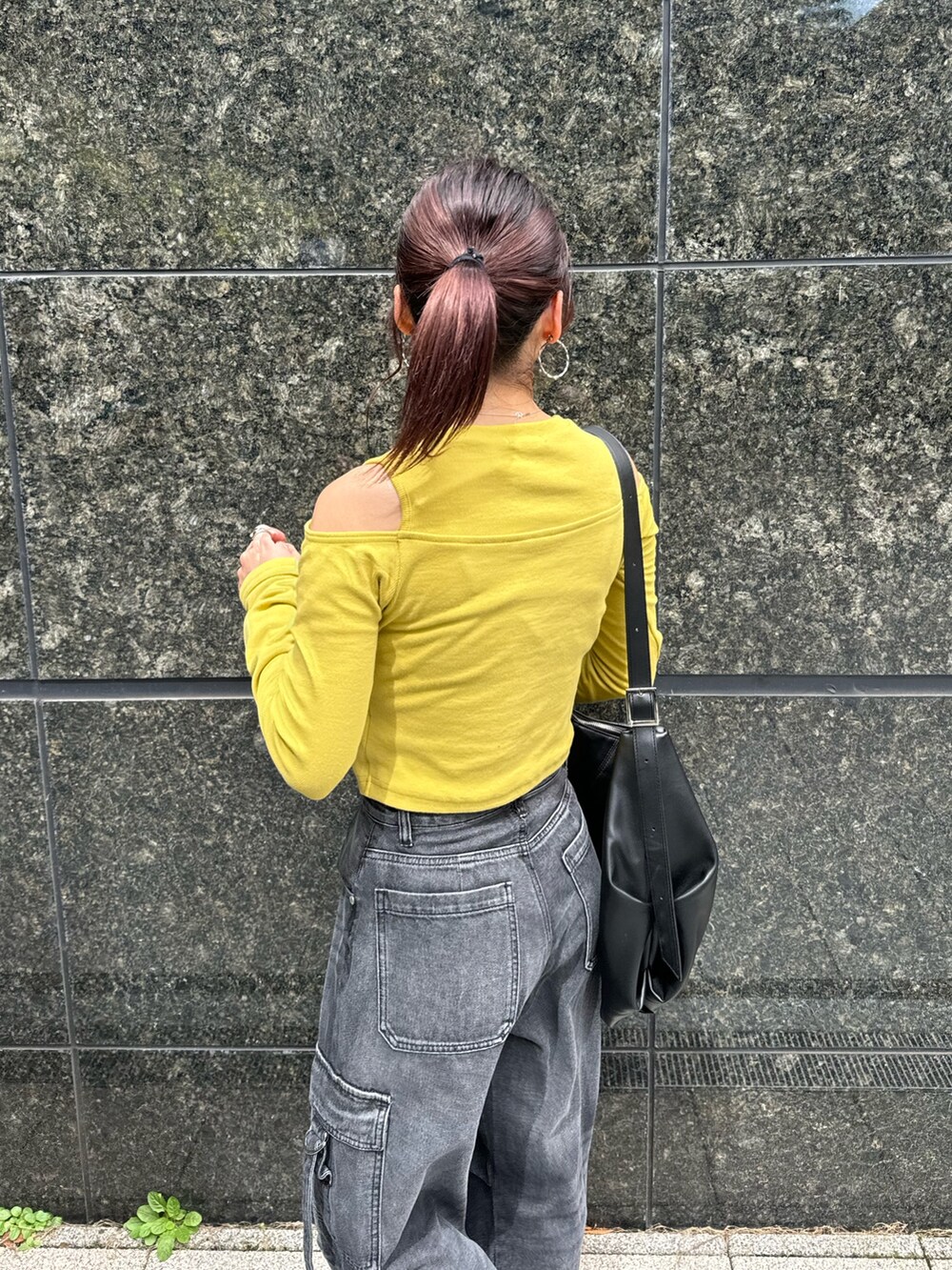 イエロー系のTシャツ/カットソー、ブラック系のデニムパンツ、ブラック系のブーツを着用したレディースの秋コーディネートの6枚目の写真