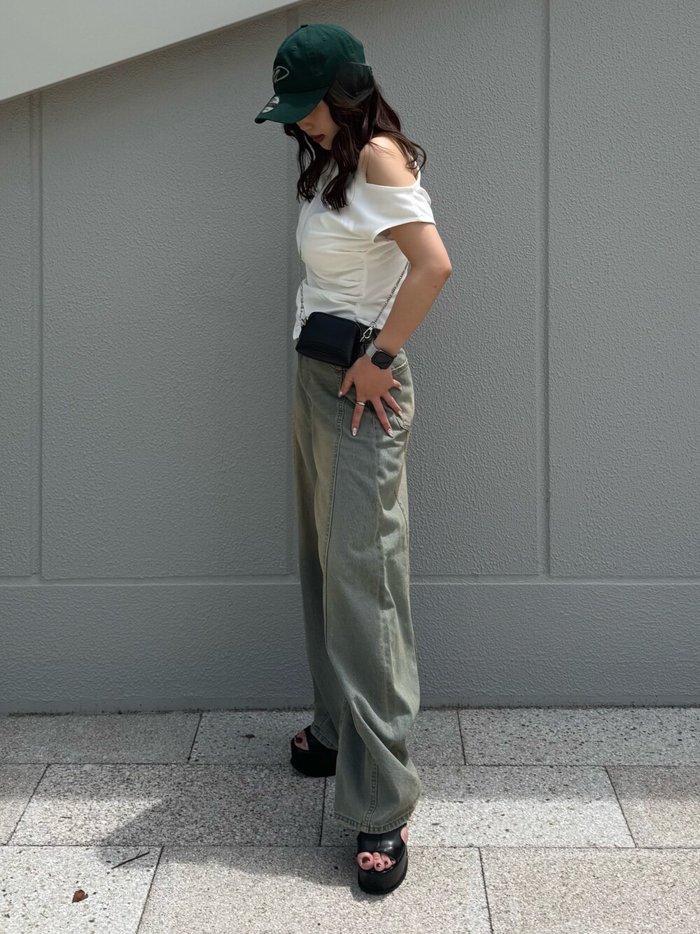 ブルー系のデニムパンツ、ホワイト系のTシャツ/カットソー、ブラック系のサンダルを着用したレディースの夏コーディネートの2枚目の写真