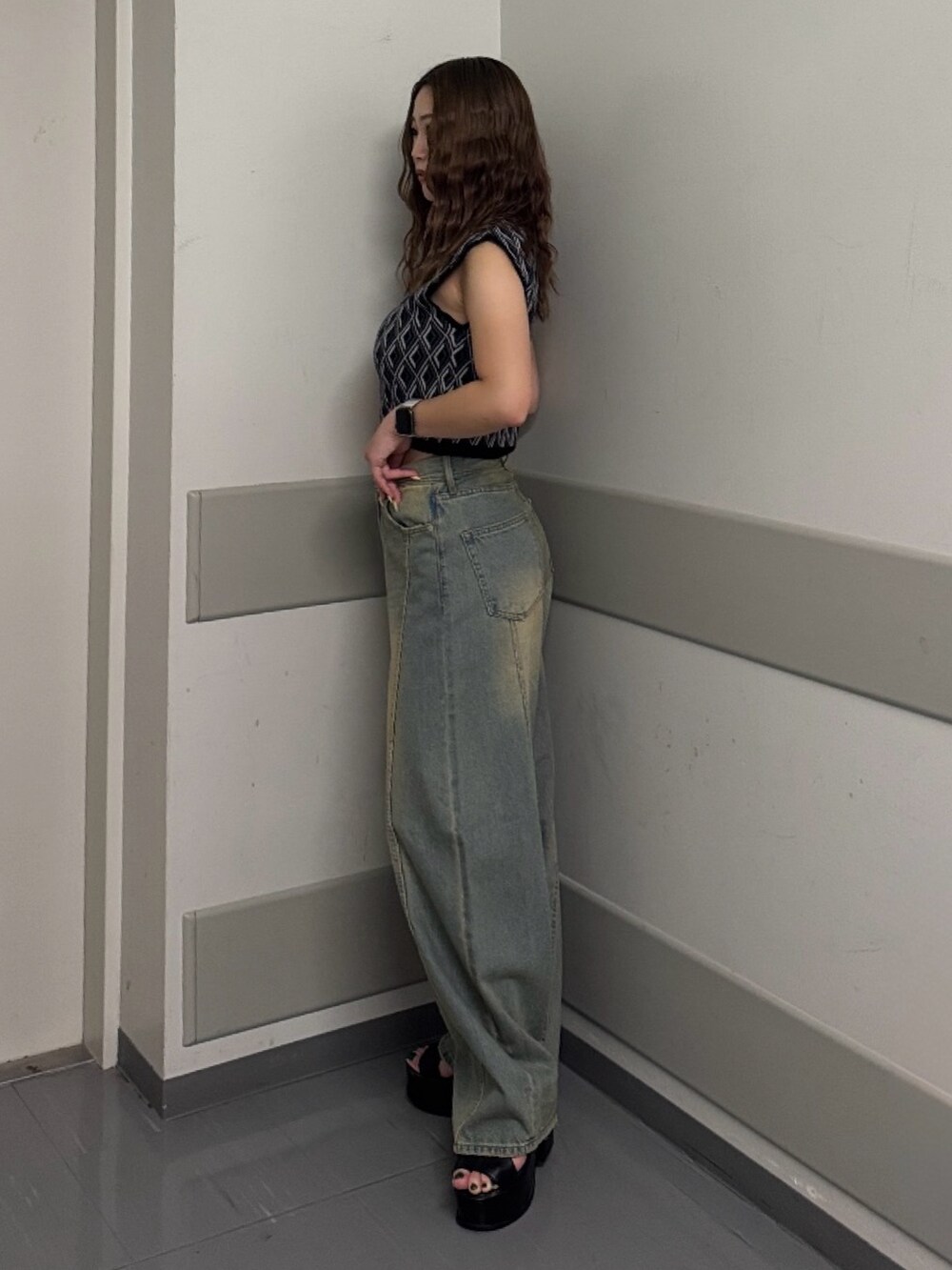 ブルー系のデニムパンツ、ブラック系のタンクトップ、ブラック系のサンダルを着用したレディースの夏コーディネートの2枚目の写真