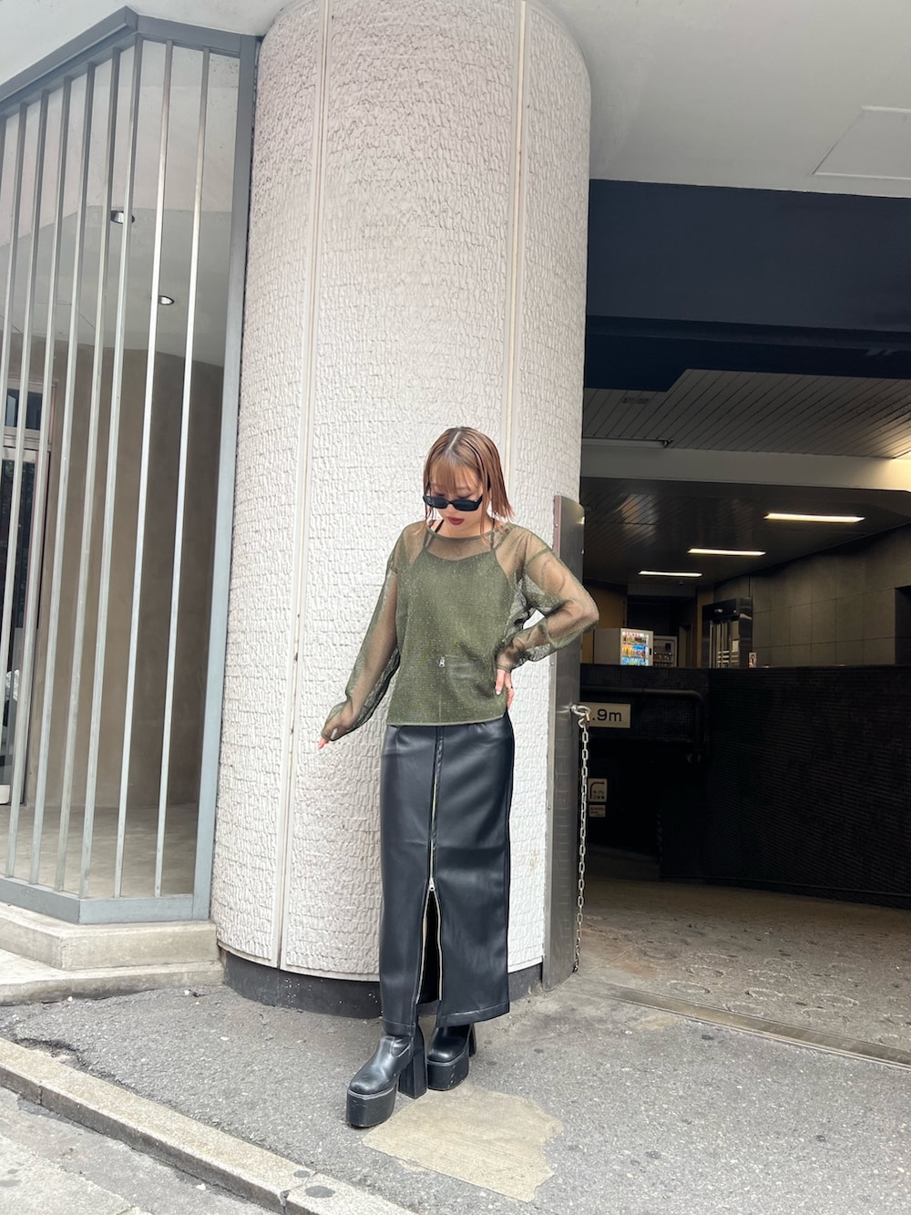 グリーン系のTシャツ/カットソー、ブラック系のスカートを着用したレディースの冬コーディネートの3枚目の写真