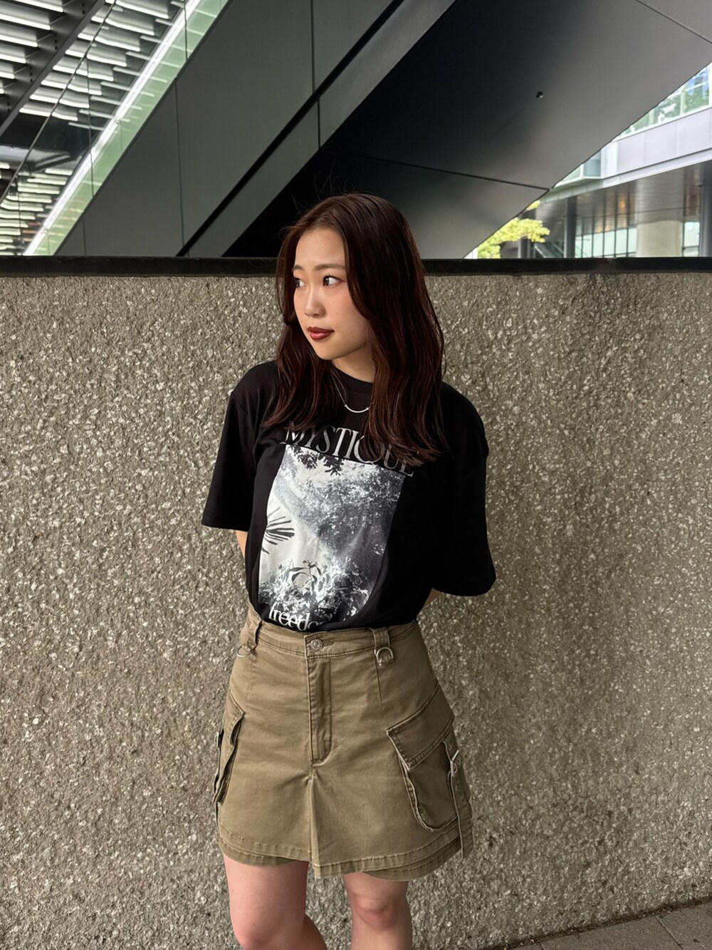 ブラック系のTシャツ/カットソー、ベージュ系のスカート、ブラック系のブーツを着用したレディースの春コーディネートの4枚目の写真