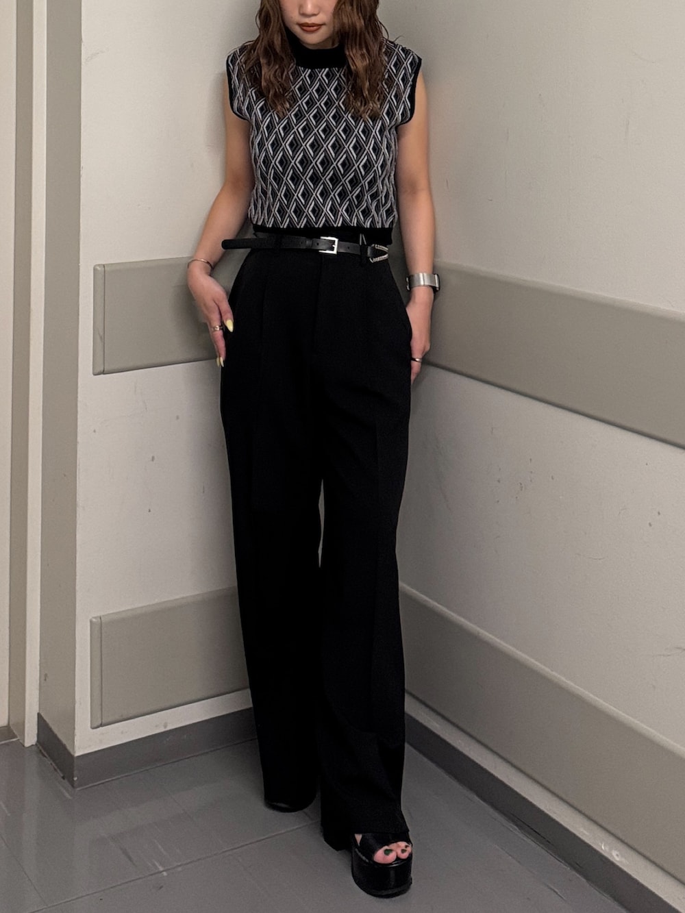 ブラック系のタンクトップ、ブラック系のスラックス、ブラック系のサンダルを着用したレディースの夏コーディネートの6枚目の写真