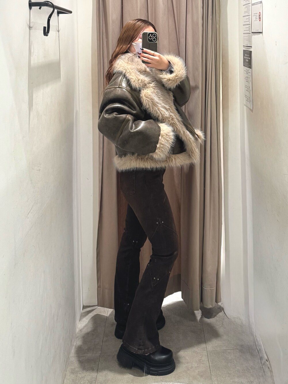 ブラック系のブーツ、ブラウン系のデニムパンツ、ブラウン系のニット/セーターを着用したレディースの秋コーディネートの2枚目の写真