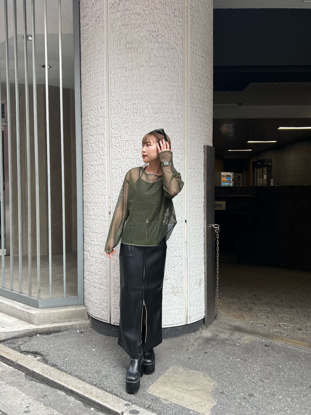 グリーン系のTシャツ/カットソー、ブラック系のスカートを着用したレディースの冬コーディネートの5枚目の写真