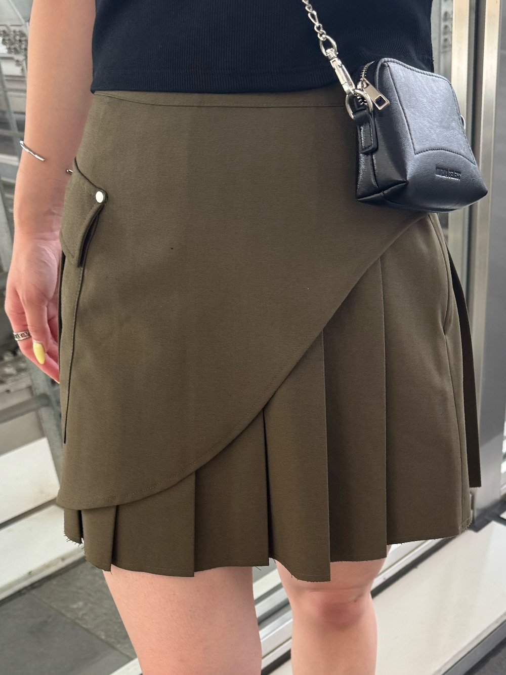 ブラック系のサンダル、グリーン系のスカート、ブラック系のTシャツ/カットソーを着用したレディースの夏コーディネートの6枚目の写真