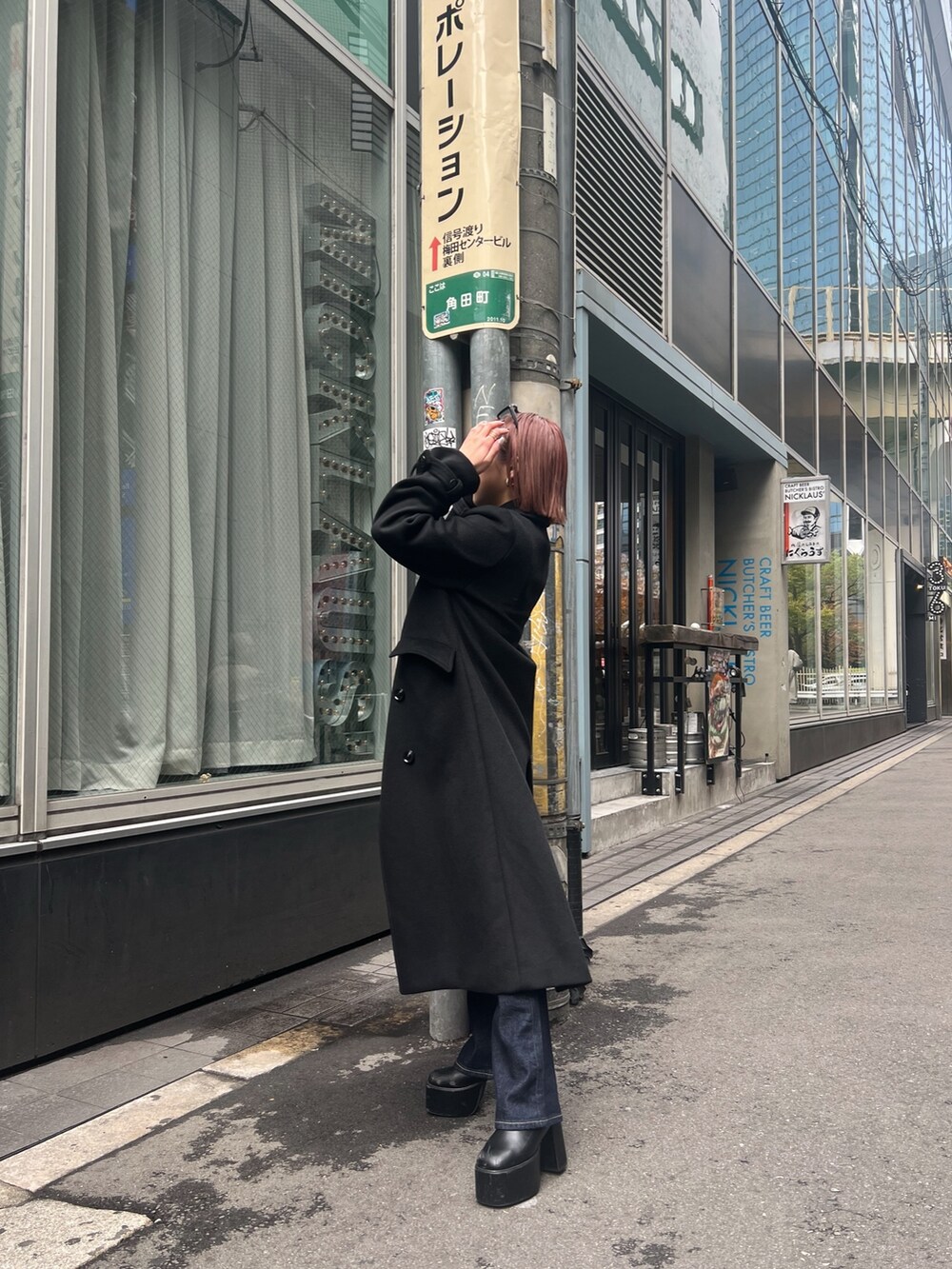 ブラック系のチェスターコートを着用したレディースの秋コーディネートの2枚目の写真