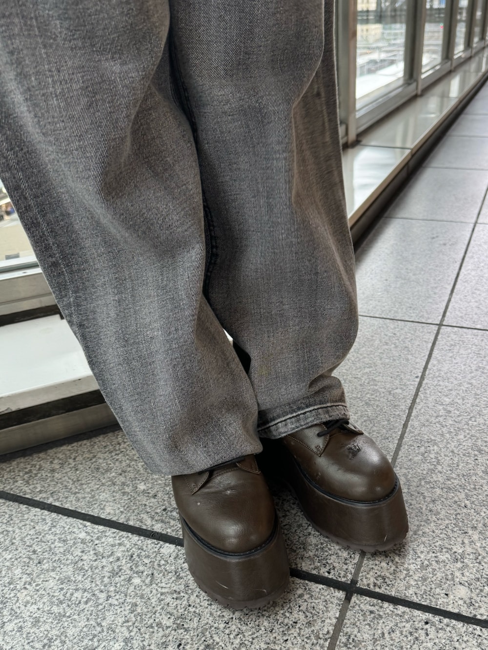 ブラック系のニット/セーター、ブラック系のデニムパンツ、ブラウン系のブーツを着用したレディースの秋コーディネートの7枚目の写真