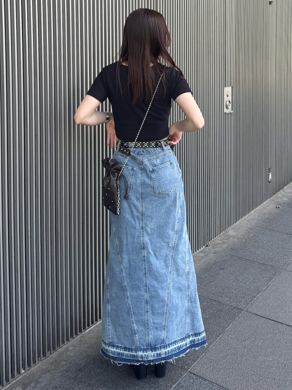 ブラック系のTシャツ/カットソー、ブルー系のデニムスカート、ブラック系のサンダルを着用したレディースの春コーディネートの3枚目の写真