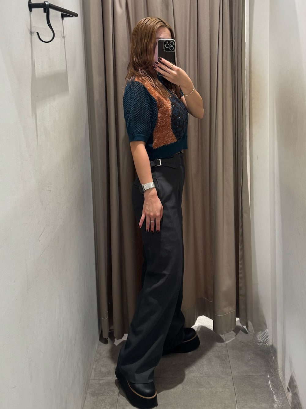 グレー系のスラックス、ブルー系のニット/セーター、ブラック系のブーツを着用したレディースの秋コーディネートの2枚目の写真