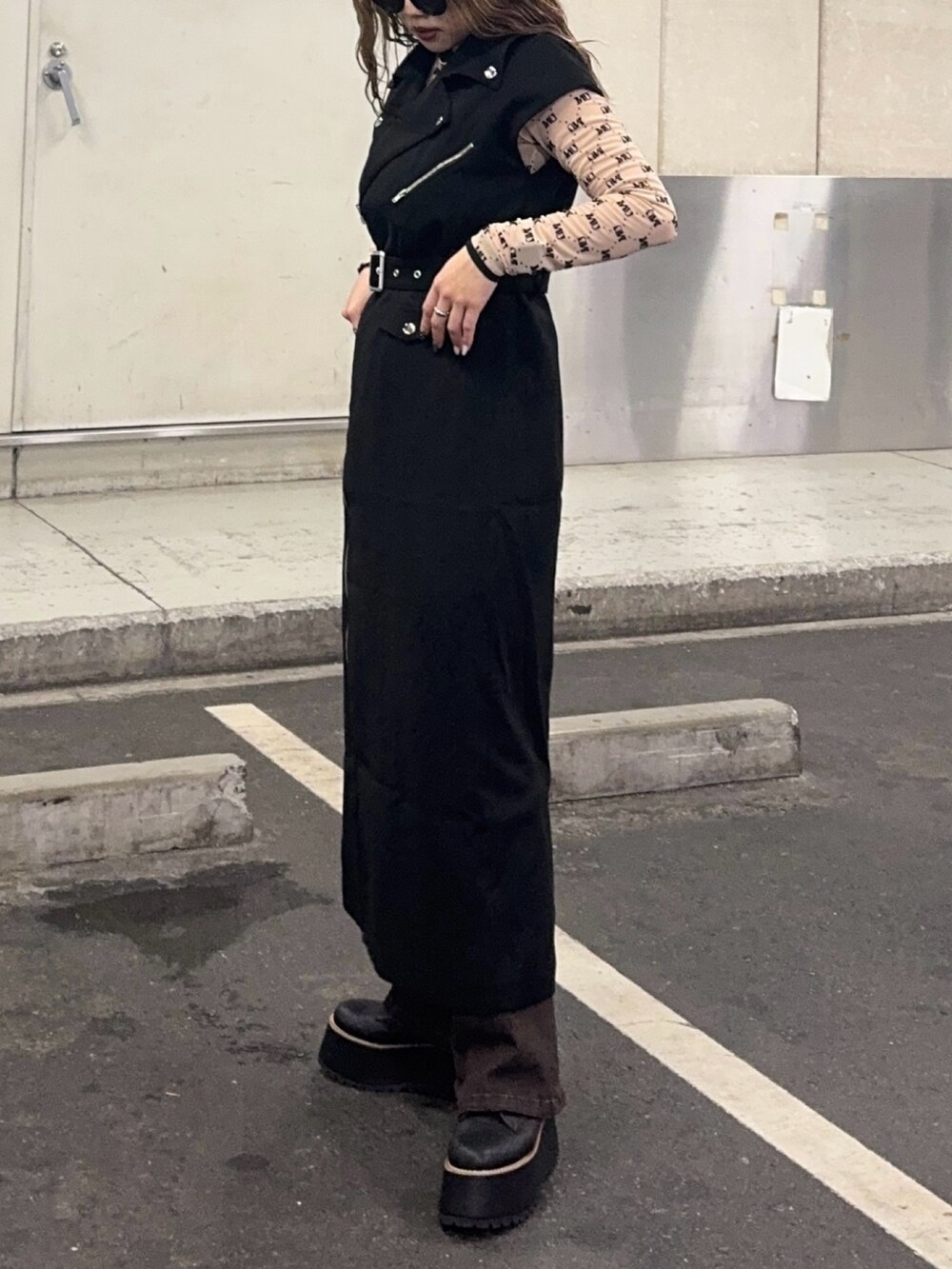 ブラウン系のデニムパンツ、ベージュ系のTシャツ/カットソー、ブラック系のワンピースを着用したレディースの秋コーディネートの5枚目の写真