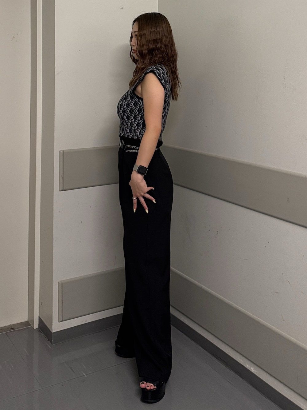 ブラック系のタンクトップ、ブラック系のスラックス、ブラック系のサンダルを着用したレディースの夏コーディネートの2枚目の写真