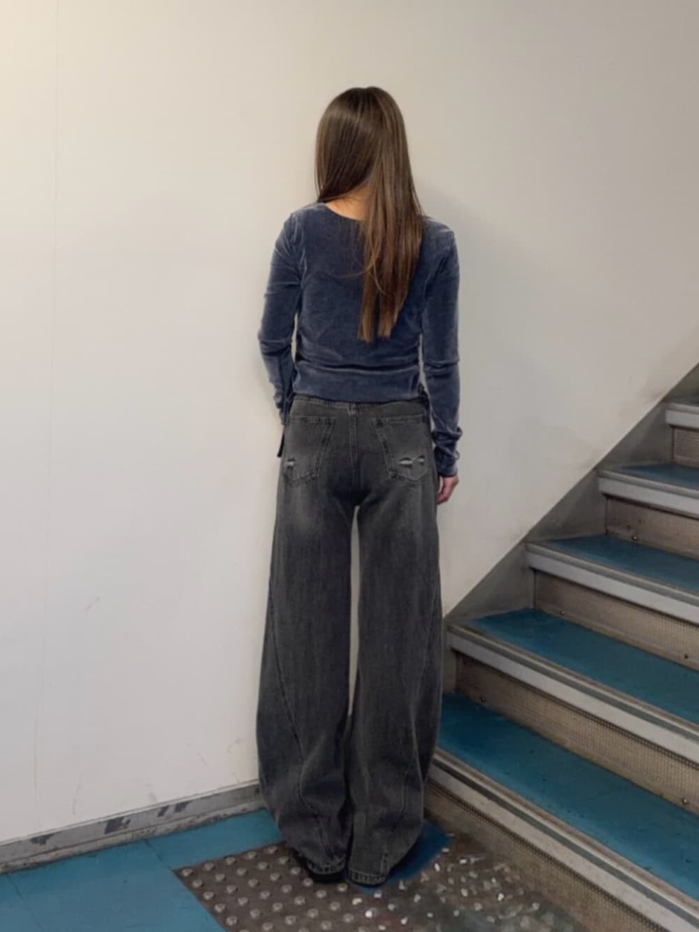 グレー系のデニムパンツ、ブラック系のブーツ、ブルー系のTシャツ/カットソーを着用したレディースの秋コーディネートの3枚目の写真