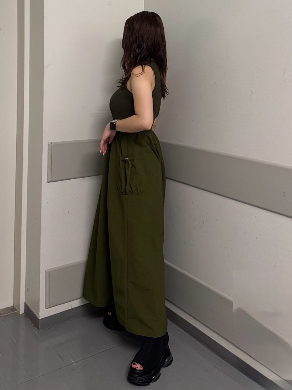 グリーン系のワンピース、ブラック系のサンダルを着用したレディースの夏コーディネートの2枚目の写真