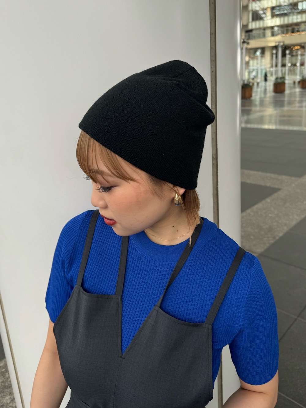 ブルー系のニット/セーター、グレー系のワンピースを着用したレディースの春コーディネートの6枚目の写真