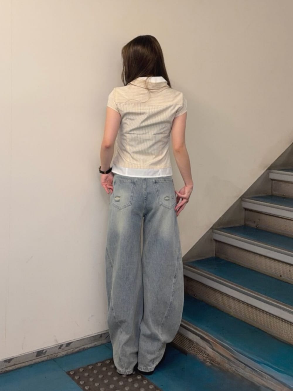 ブルー系のデニムパンツ、ブラック系のブーツ、イエロー系のシャツ/ブラウスを着用したレディースの夏コーディネートの3枚目の写真