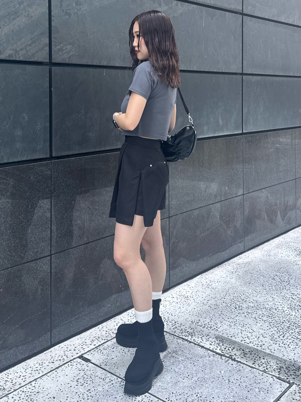 グレー系のTシャツ/カットソー、ブラック系のスカート、ブラック系のブーツを着用したレディースの春コーディネートの2枚目の写真