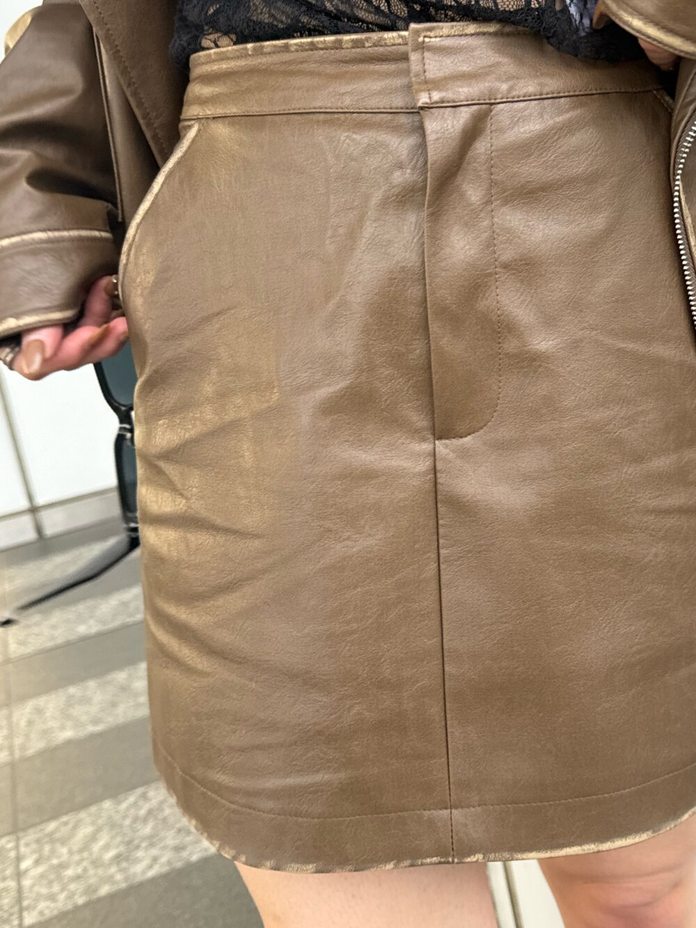 ブラック系のTシャツ/カットソー、ブラウン系のライダースジャケット、ブラウン系のスカートを着用したレディースの秋コーディネートの7枚目の写真