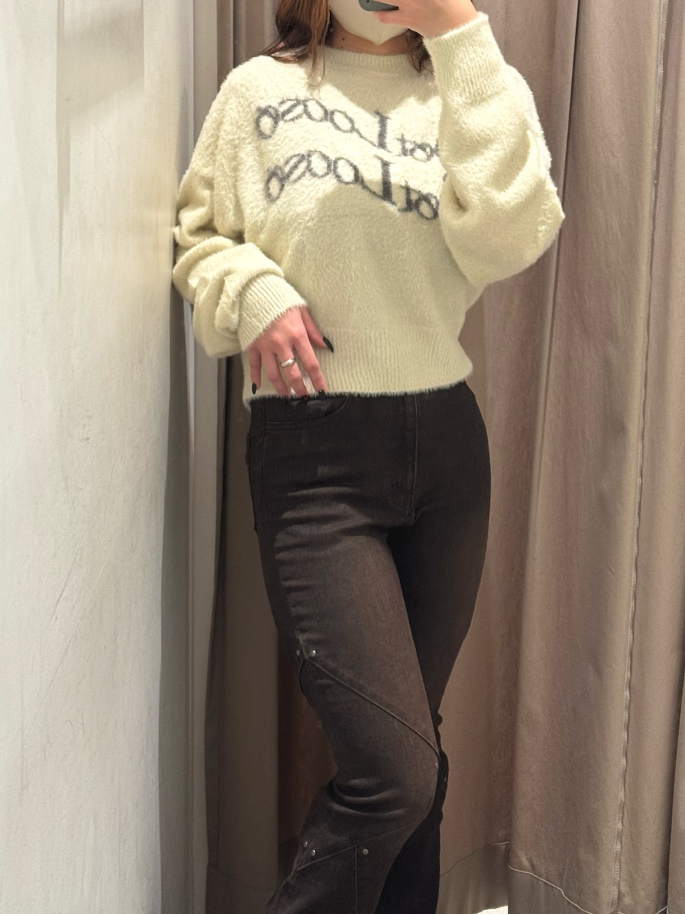 ホワイト系のニット/セーター、ブラウン系のデニムパンツ、ブラック系のブーツを着用したレディースの秋コーディネートの4枚目の写真