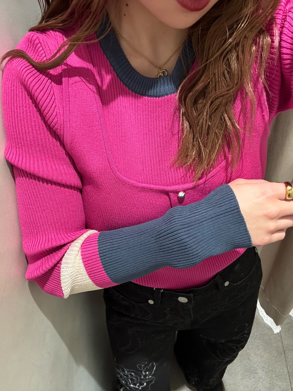 ピンク系のニット/セーター、ブラック系のデニムパンツ、ブラック系のブーツを着用したレディースの冬コーディネートの5枚目の写真