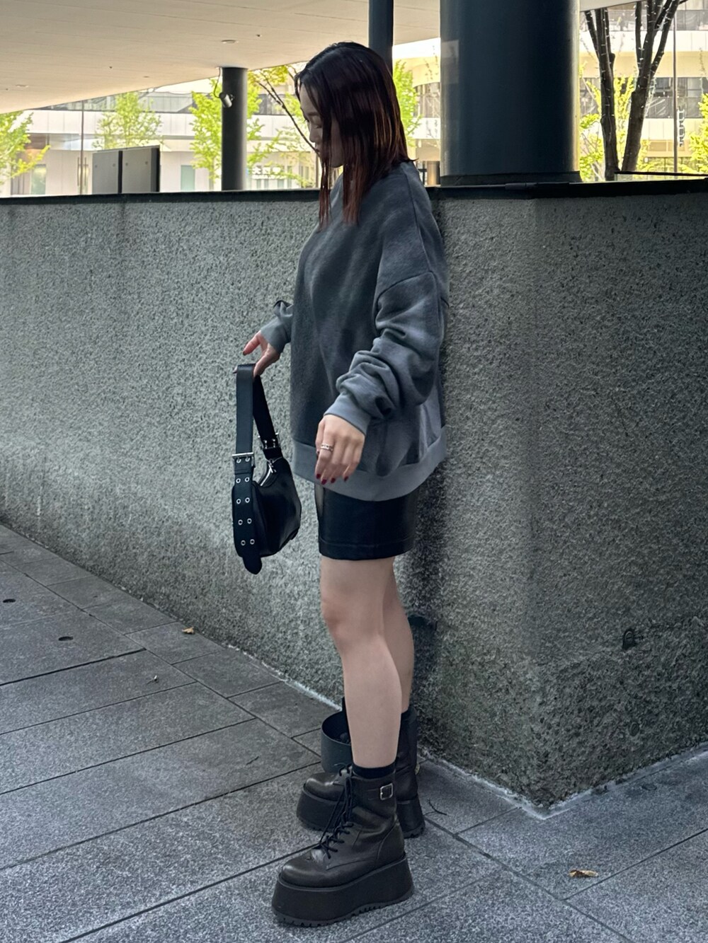 グレー系のスウェット、ブラック系のスカート、ブラック系のハンドバッグを着用したレディースの秋コーディネートの2枚目の写真