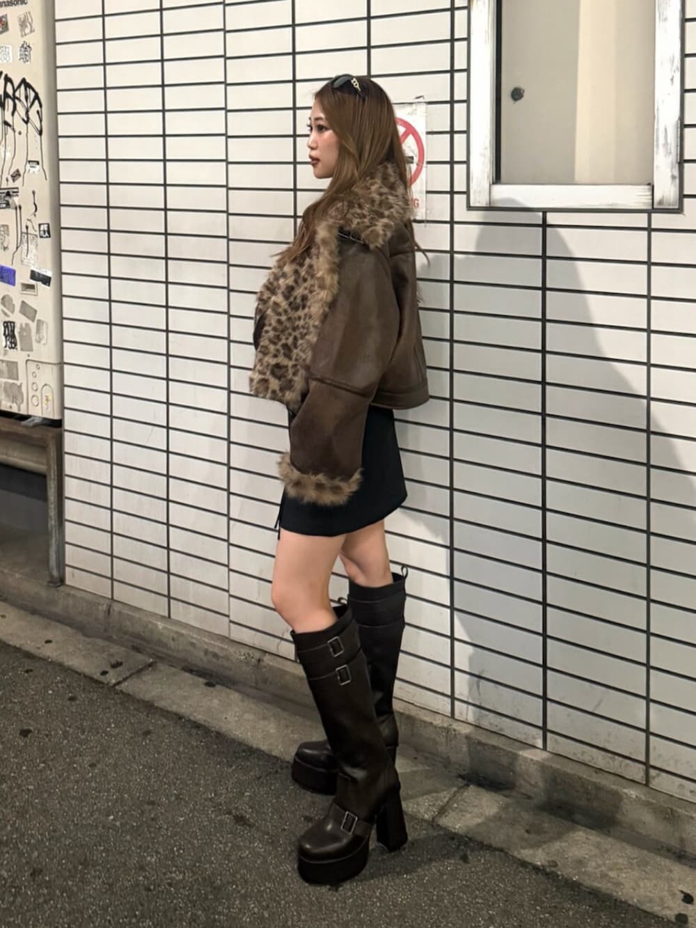 その他のムートンコート、ブラック系のスカート、ブラック系のブーツを着用したレディースの夏コーディネートの2枚目の写真