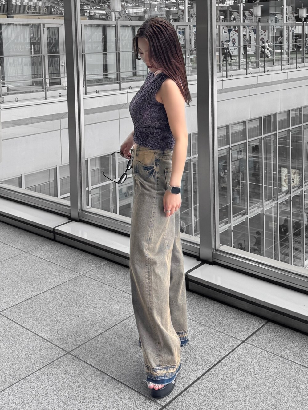 オレンジ系のタンクトップ、その他のデニムパンツ、ブラック系のサンダルを着用したレディースの春コーディネートの2枚目の写真