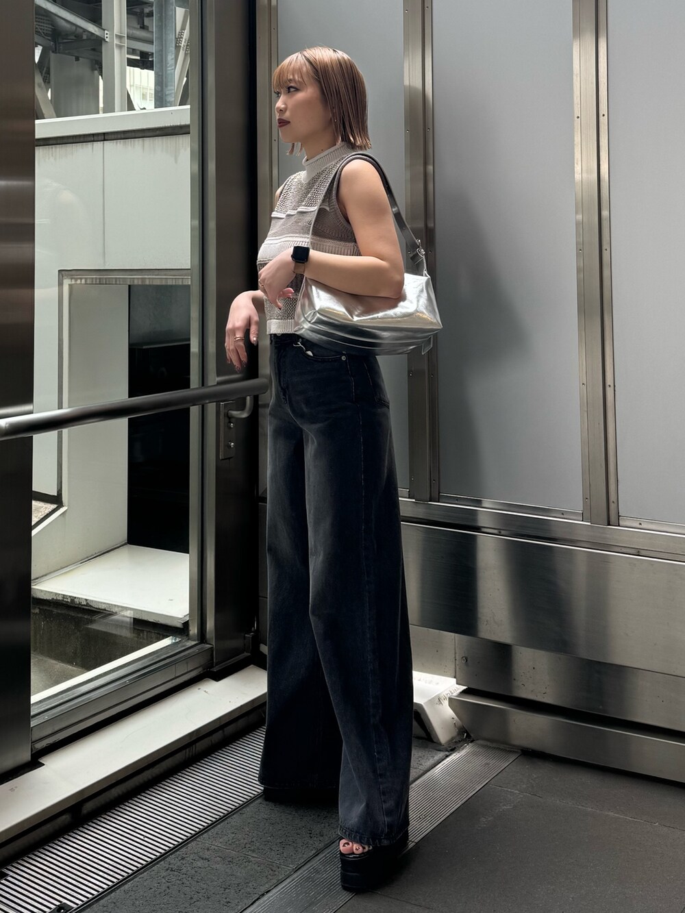 グレー系のニット/セーター、ブラック系のデニムパンツを着用したレディースの春コーディネートの6枚目の写真