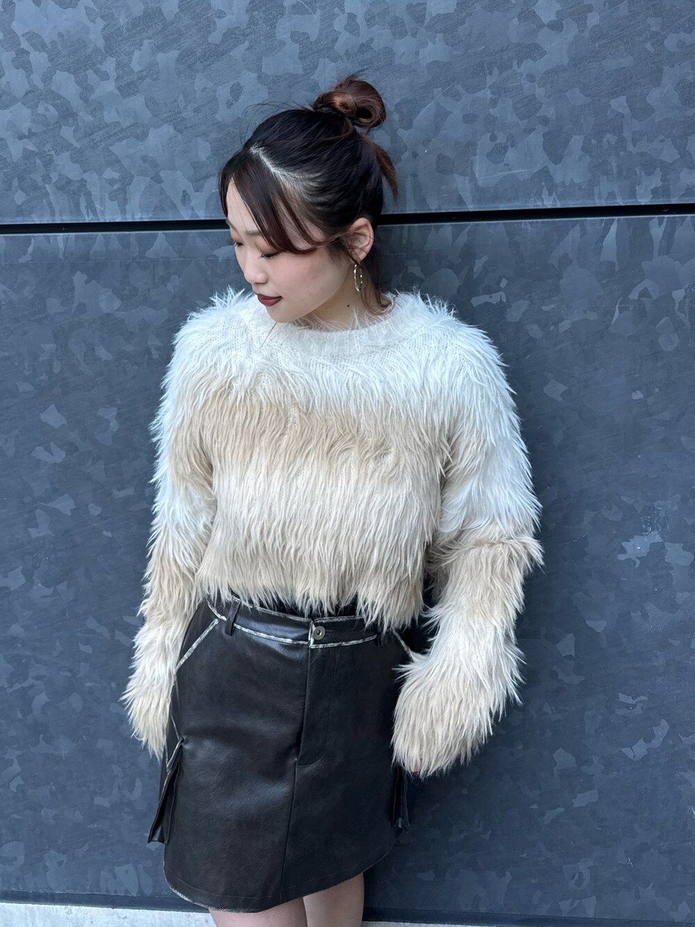 ホワイト系のニット/セーター、ブラウン系のスカート、ブラック系のブーツを着用したレディースの冬コーディネートの4枚目の写真