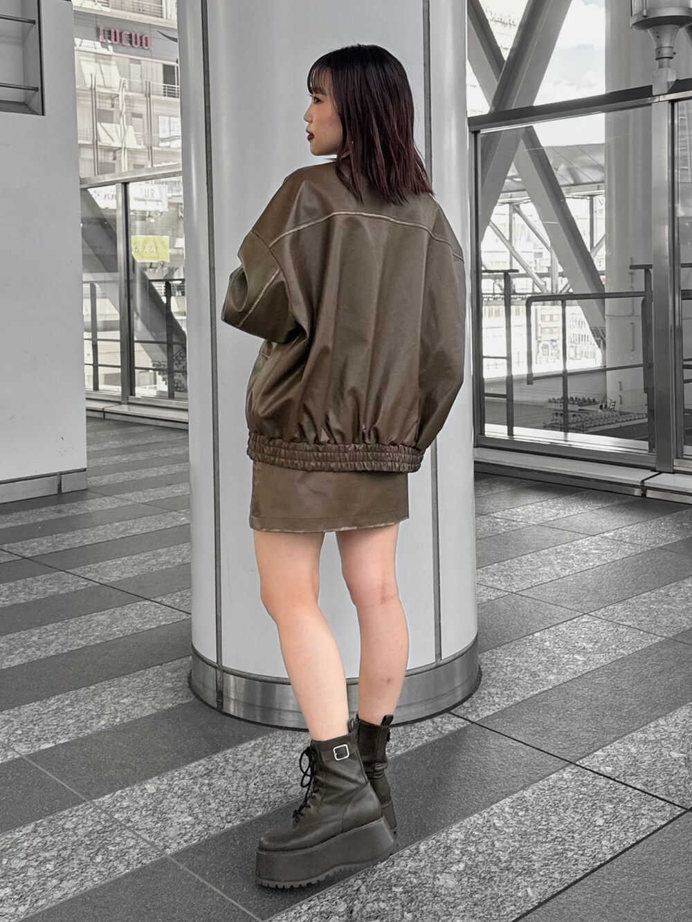 ブラック系のTシャツ/カットソー、ブラウン系のライダースジャケット、ブラウン系のスカートを着用したレディースの秋コーディネートの3枚目の写真